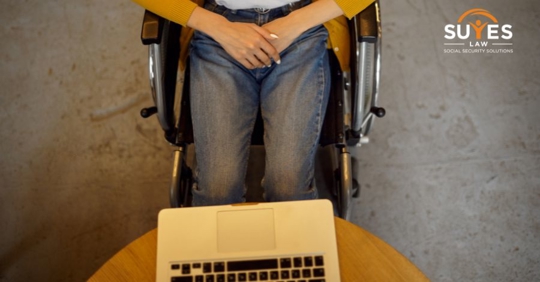 person on wheelchair using laptop